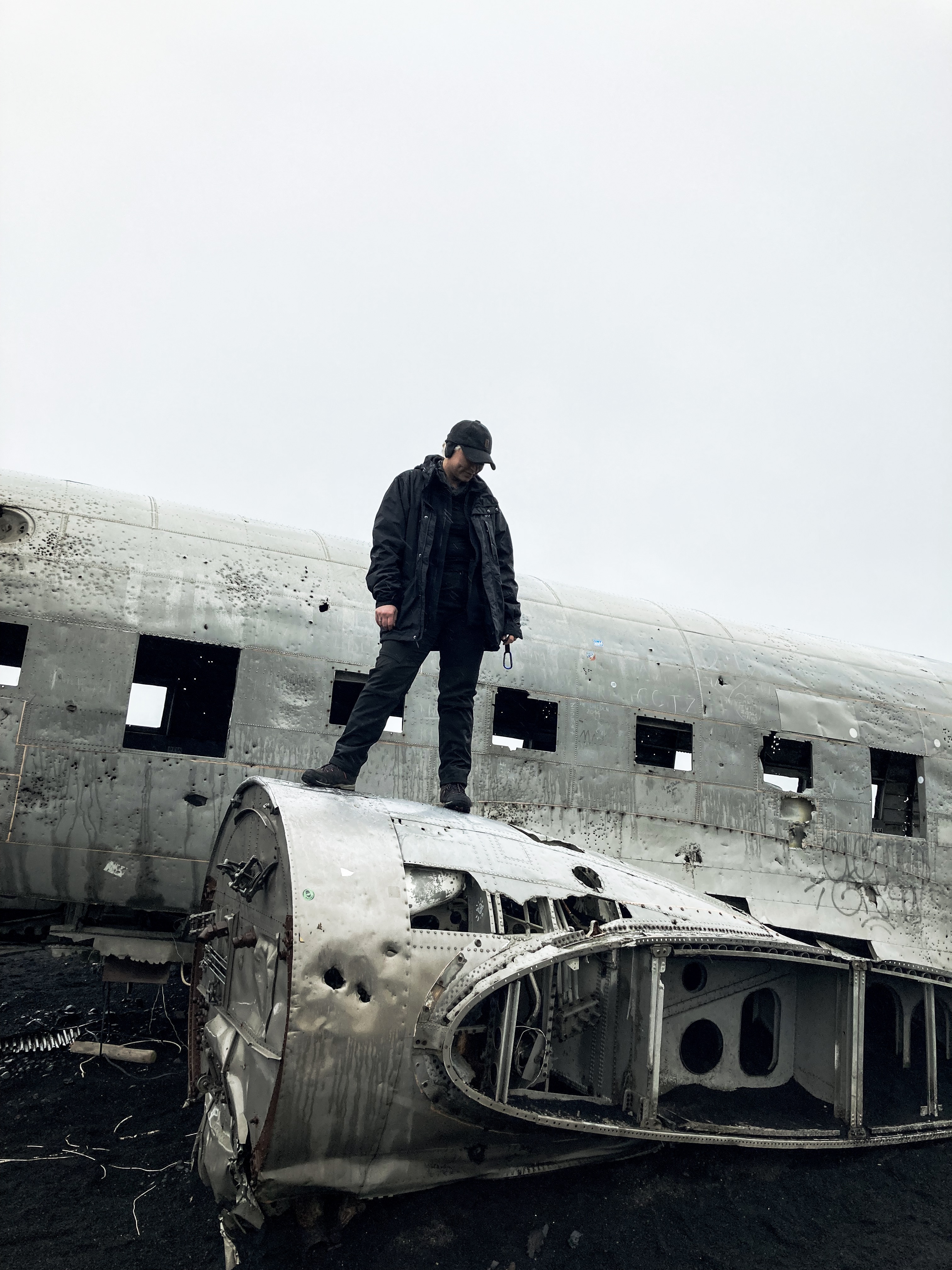 A young woman standing on the famous DC-3 Plane Wreck in Iceland